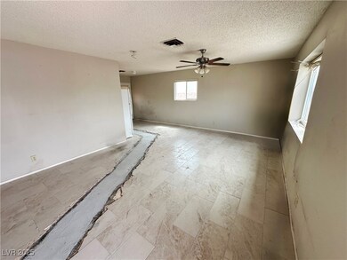 Unfurnished room with a ceiling fan and a textured