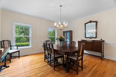 The formal dining room flows seamlessly from the living area, offering an elegant space with gleaming hardwood floors and an open layout ideal for hosting gatherings.