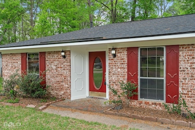 Property entrance with a shingled roof and brick s