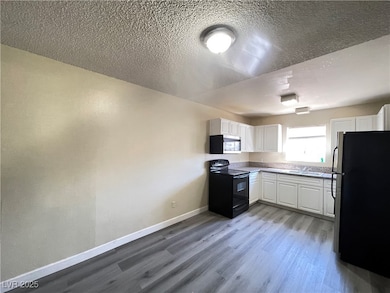 Kitchen featuring dark wood finished floors, baseb
