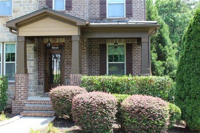 View of exterior entry featuring brick siding and a porch