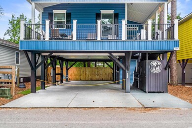 Raised beach house featuring a carport, driveway, and covered porch