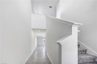 Stairway featuring baseboards and a towering ceiling