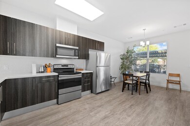 Kitchen with stainless steel appliances, dark brown cabinets, backsplash, modern cabinets, and a chandelier
