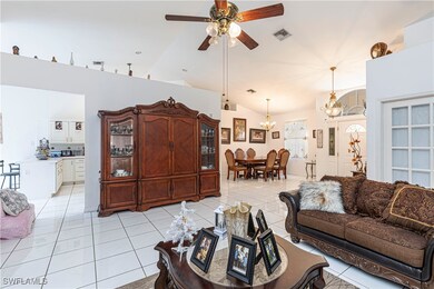 Living room featuring a ceiling fan, light tile pa