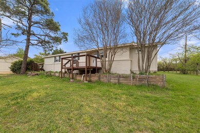 Back of property with a garden, a deck, and a lawn
