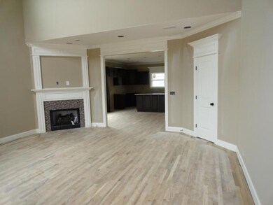 Open floor plan into the kitchen.  Corner fireplace.  Sand and finish hardwood floors