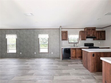 Kitchen featuring black appliances, a sink, light 