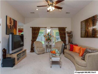 Family room with wood burning fireplace, soaring ceilings and ceiling fan