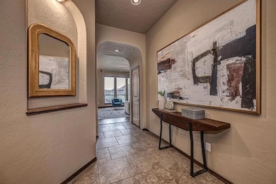 Hallway with baseboards, arched walkways, a textur
