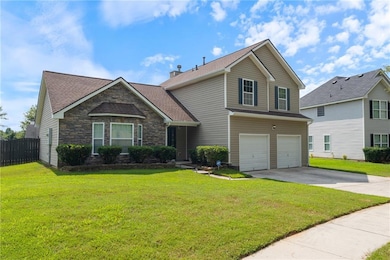 Traditional-style house featuring driveway, an attached garage, a shingled roof, and stone siding