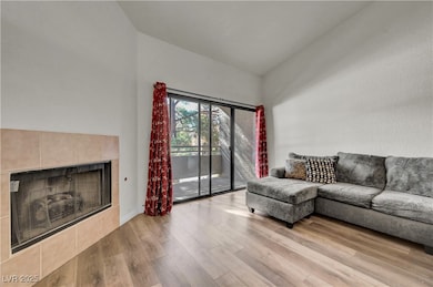 Living room featuring light wood-style floors and a tiled fireplace