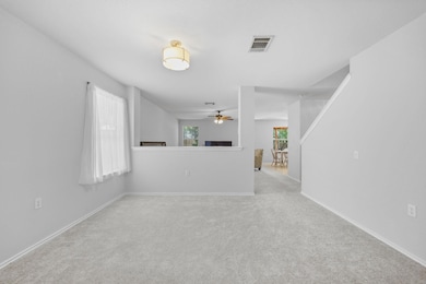 Unfurnished living room featuring a ceiling fan a