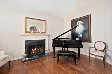 Living room with cathedral ceiling, gas fireplace, hardwood flooring.