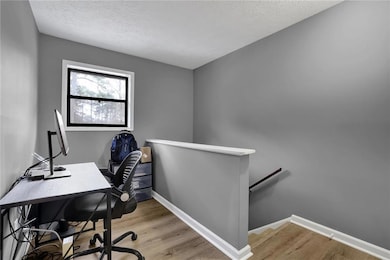 Home office featuring a textured ceiling and light wood-style floors