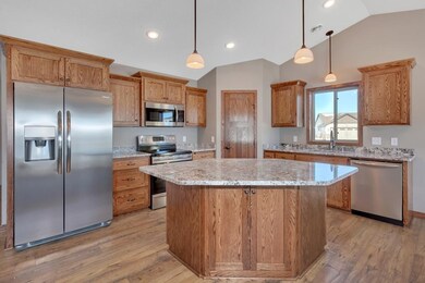 Kitchen with oak cabinetry, granite counters, walk