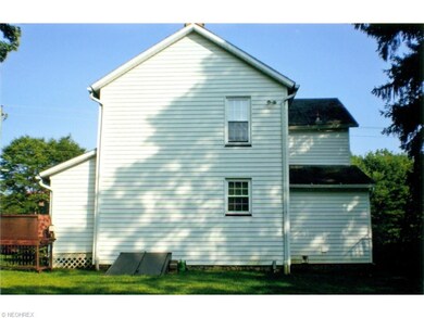rear view of home w deck; outdoor entry to basemen
