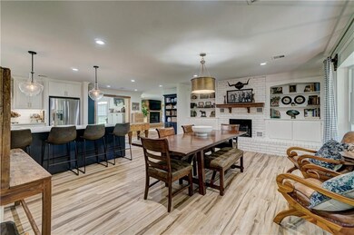 Formal Dining room with a real masonry fireplace, currently housing faux electric logs.  The Bay Window really frames the front of the house.  In the far distance you can see the main living area fireplace and at the left of the picture the breakfast