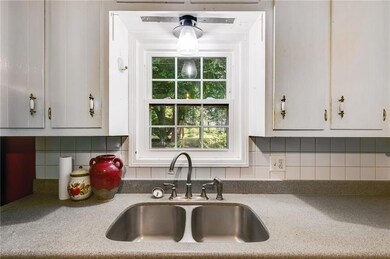 Kitchen featuring a sink, white cabinets, and decorative backsplash