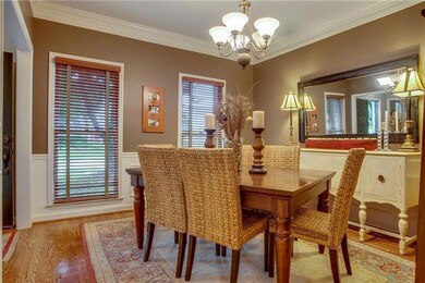 This inviting Dining Room has an updated fixture, hardwoods, wood blinds, and adjoins the kitchen for easy entertaining.