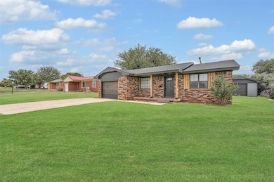 Ranch-style house featuring concrete driveway, brick, and wood post porch