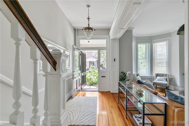 Foyer entrance featuring light hardwood / wood-style flooring and a chandelier