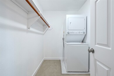 large walk in closet with laundry in unit
