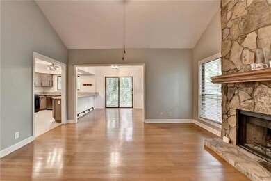 Unfurnished living room with light wood finished floors, a fireplace, healthy amount of natural light, and high vaulted ceiling