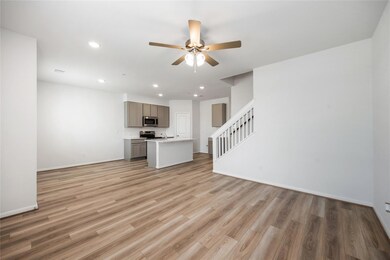 Unfurnished living room with ceiling fan, baseboa