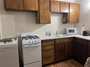 Kitchen with white appliances, wood finished floors, and light countertops