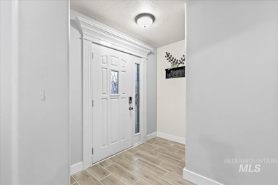 Entryway featuring wood tiled floors and a textured ceiling
