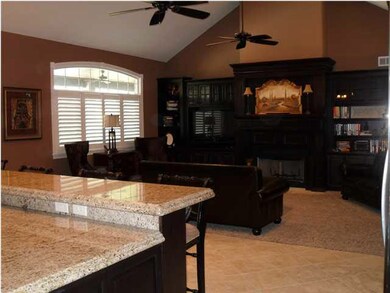 The kitchen features a raised breakfast bar and gr