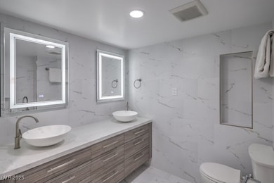 Bathroom with visible vents, a sink, toilet, and m