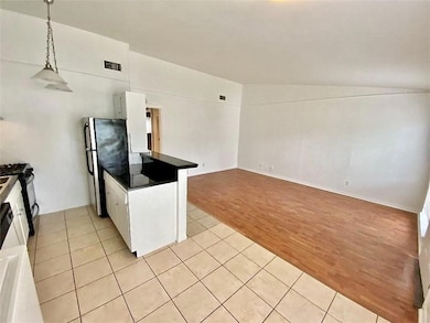 Kitchen featuring freestanding refrigerator, dark