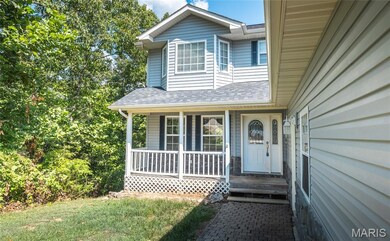 Doorway to property with a shingled roof and covered porch