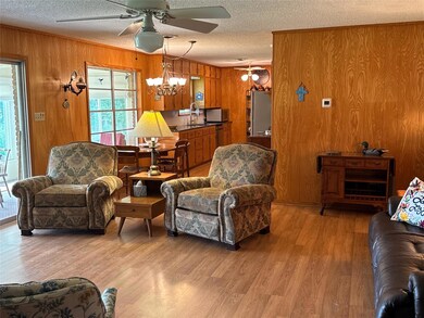 Living area with a textured ceiling, ceiling fan,