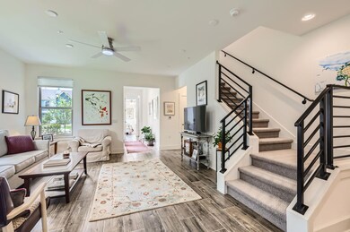 Living room with stairway, a ceiling fan, wood fi