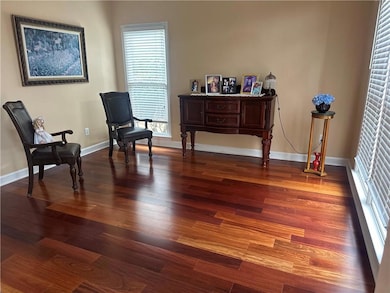 Sitting room with wood finished floors and baseboa