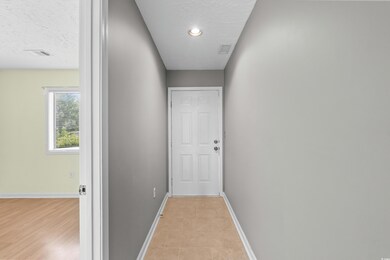Corridor with a textured ceiling and baseboards