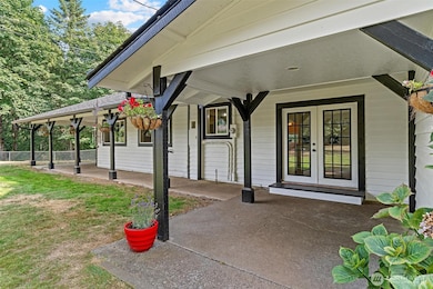 Covered front porch area with French doors entering into kitchen.