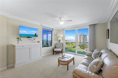 Carpeted living room with ceiling fan and crown mo