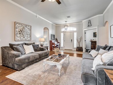 Living room featuring ceiling fan, crown molding, 