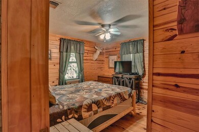 Bedroom with wood walls, a textured ceiling, ceili