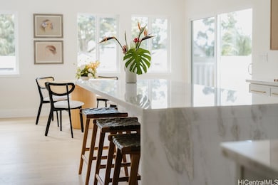 One of the home’s many delights is the abundance of inviting places to gather—whether sharing a meal at the kitchen island, lingering in the sunny breakfast nook, dining formally indoors, or savoring the breeze across multiple outdoor lanais.