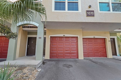 Doorway to property with a garage, driveway, and stucco siding