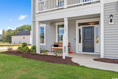 Doorway to property featuring covered porch, a lawn, and a balcony