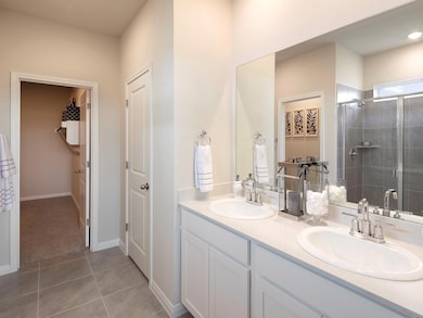 Full bathroom featuring double vanity, a shower s