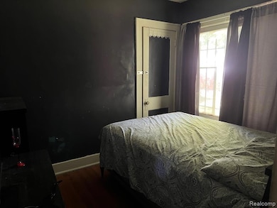 Bedroom with baseboards and dark wood-style floors