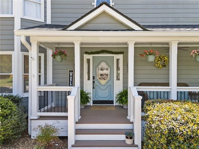 Doorway to property with a shingled roof and cover