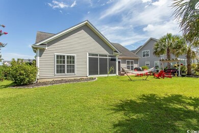 Back of property with a pergola and a lawn